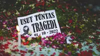 Lilin dan tulisan yang diletakkan di Stadion Kanjuruhan untuk mengenang tragedi menyesakkan pada 1 Oktober 2022. Foto diambil pada Senin (11/10/2022). (Bola.com/Bagaskara Lazuardi)
