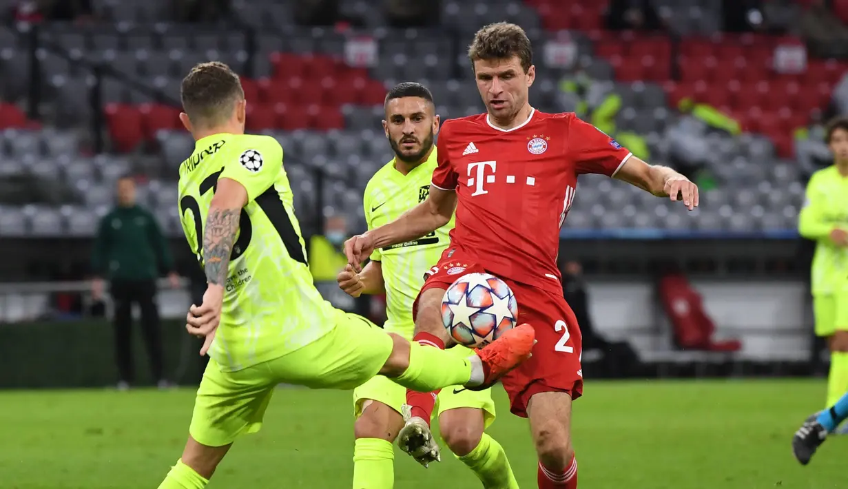 Penyerang Bayern Munchen, Thomas Mueller, berebut bola dengan bek Atletico Madrid, Kieran Trippier, pada laga Grup A Liga Champions 2020/2021 di Allianz Arena, Kamis (22/10/2020) dini hari WIB. Bayern Munchen menang 4-0 atas Atletico Madrid. (AFP/Andreas Gebert/pool)