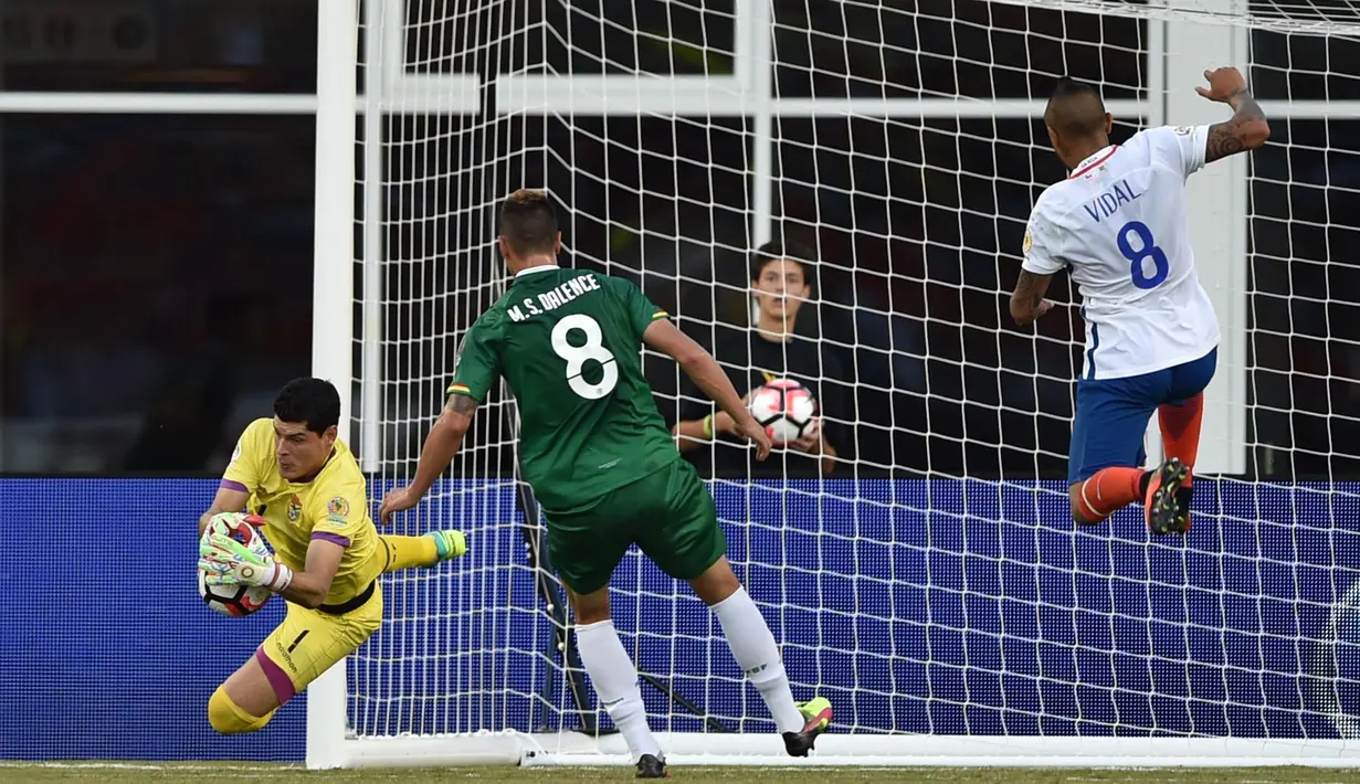Kiper Bolivia, Carlos Lampe menyelamatkan gawangnya dari serangan pemain Chile Arturo Vidal pada babak penyisihan grup Copa America Centenario 2016 di Stadion Gillette, Foxborough, AS, Sabtu (11/6/2016) WIB.  (AFP/Hector Retamal)