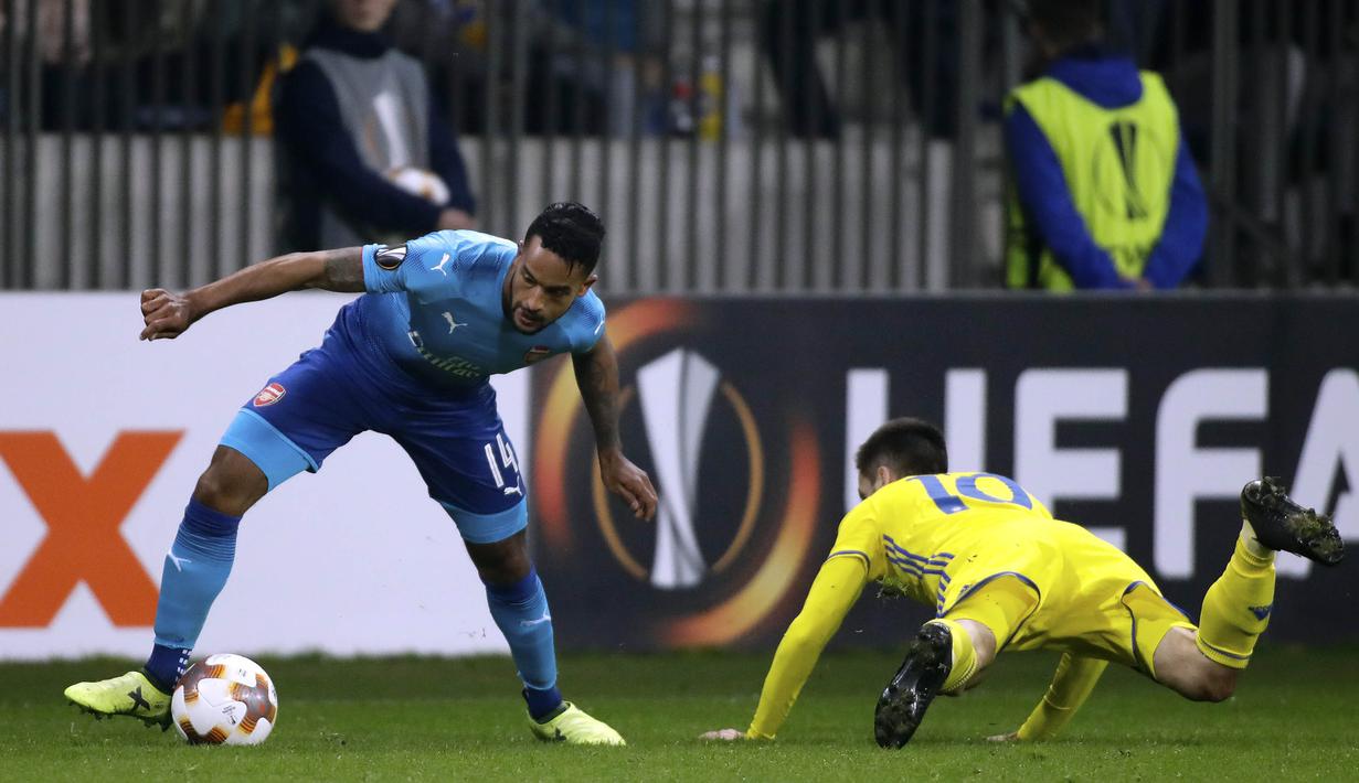 Gelandang Arsenal, Theo Walcott, melewati gelandang BATE Borisov, Mirko Ivanic, pada laga Liga Europa di Stadion Borisov, Kamis (28/9/2017). Arsenal menang 4-2 atas BATE Borisov. (AP/Sergei Grits)