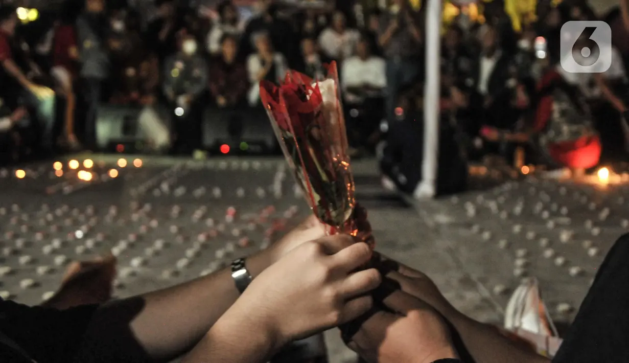 Aktivis membagikan bunga saat aksi 4.000 lilin untuk mengenang Brigadir Novriansyah Joshua Hutabarat alias Brigadir J di kawasan Taman Ismail Marzuki (TIM), Jakarta, Kamis (18/8/2022). Aksi solidaritas keadilan bertajuk 4.000 lilin digelar untuk memperingati 40 hari kematian Brigadir Nofriansyah Yosua Hutabarat alias Brigadir J. (merdeka.com/Iqbal S. Nugroho)