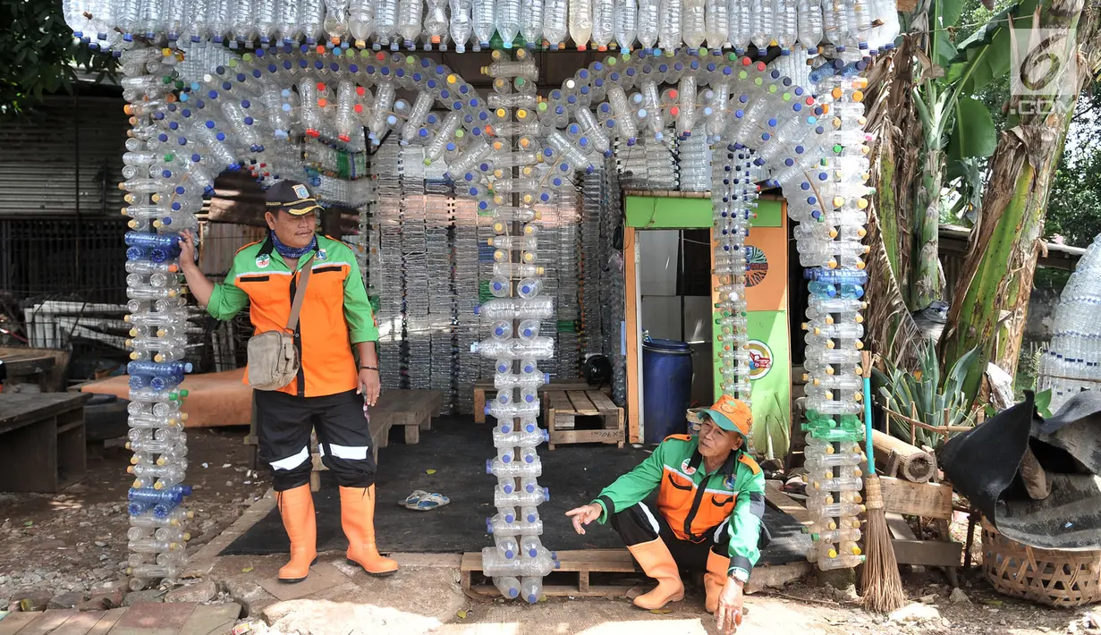 Petugas UPK Badan Air DLH DKI Jakarta bersantai di depan Pos Botol Plastik di Pasar Rebo, Jakarta, Selasa (12/3). Petugas memanfaatkan botol plastik bekas untuk membangun pos cantik. (merdeka.com/Iqbal Nugroho)