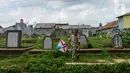 Anak-anak bermain layang-layang di Tanah Makam Cipinang Besar Utara, Jakarta, Selasa (14/1/2020). Pemprov DKI Jakarta berencana terus menambah Ruang Publik Terpadu Ramah Anak (RPTRA) di sejumlah wilayah. (merdeka.com/Imam Buhori)