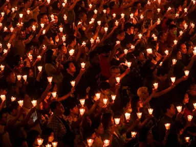 Umat Kristen memegang lilin saat ibadah malam Natal di Gereja Bethany, Surabaya, Jawa Timur, Minggu (24/12/2023). Pelaksanaan ibadah malam Natal berjalan aman dan lancar. (Juni KRISWANTO/AFP)