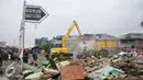 Alat berat merobohkan bangunan di kawasan prostitusi Kalijodo, Jakarta Utara, Senin (29/2). Puluhan bangunan di kawasan tersebut mulai rata dengan tanah serta menjadi tontonan warga. (Liputan6.com/Gempur M Surya)