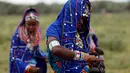 Seorang wanita dari suku Maasai menyiapkan sepatu untuk mengikuti Olimpiade Masai 2016 di cagar alam Sidai Oleng, kaki Gunung Kilimanjaro dekat perbatasan Kenya-Tanzania (10/12). (Reuters/Thomas Mukoya)