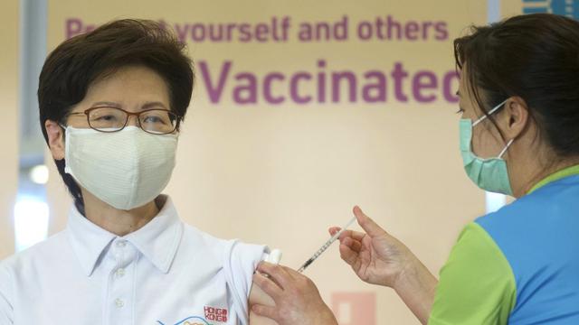 <span>Pimpinan Eksekutif Hong Kong Carrie Lam (kiri), menerima suntikan vaksin COVID-19 di Community Vaccination Centre di Hong Kong pada Senin (22/2/2021). (Photo credit: AP Photo/Vincent Yu)</span>