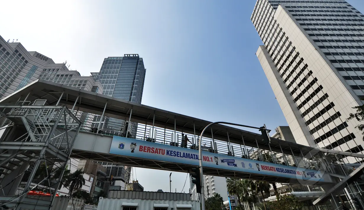Sejumlah orang menyeberang melalui Jembatan Penyeberangan Orang (JPO)  Bundaran HI, Jakarta, Jumat (20/3/2015). Pemprov DKI akan menjadikan JPO di kawasan Bundaran HI sebagai standar JPO yang ada di Jakarta nanti. (Liputan6.com/Faizal Fanani)