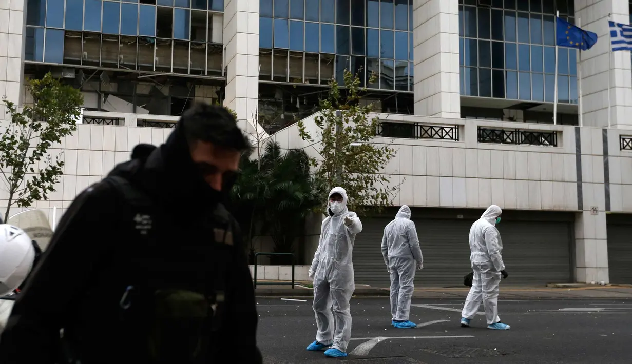 Petugas kepolisian mencari barang bukti usai ledakan bom di Pengadilan Banding di Athena, Jumat, (22/12). Polisi Yunani melaporkan tidak ada korban jiwa akibat kejadian tersebut. (AP Photo / Thanassis Stavrakis)