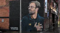 Mural pelatih klub Liverpool, Jurgen Klopp di Jamaica Street, pusat kota Baltic Triangle di Liverpool, Senin (10/12). Banyak yang menyambut baik pembuatan mural itu namun tidak sedikit pula yang mencibir, termasuk suporter klub Everton. (Paul ELLIS / AFP)