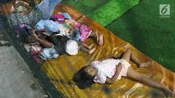 Anak-anak korban Tsunami Anyer mengungsi di lapangan futsal Labuan, Banten, Minggu (23/12). Tsunami yang menerjang wilayah Selat Sunda memilih warga mengungsi sejak siang hari. (Liputan6.com/Angga Yuniar)