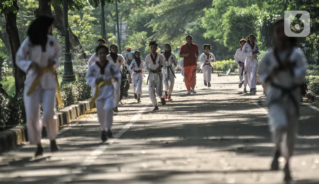 Murid Taekwondo Indonesia Manroe Club melakukan pemanasan sebelum latihan rutin di kawasan Kanal Banjir Timur (KBT), Jakarta Timur, Senin (16/8/2021). Meski di ruang terbuka, latihan berlangsung dengan menerapkan protokol kesehatan. (merdeka.com/Iqbal S. Nugroho)