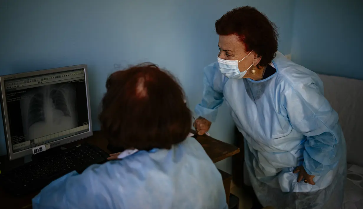 Spesialis penyakit menular Dr Maria Bogoeva (kanan) dan rekannya memeriksa gambar rontgen paru-paru pasien Covid-19 di sebuah rumah sakit kecil di Bulgaria pada 20 Januari 2021. Perempuan berusia 82 tahun itu siap untuk pensiun ketika pandemi virus corona melanda. (Dimitar DILKOFF/AFP)