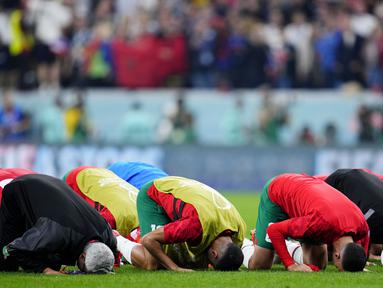Skuad Timnas Maroko melakukan sujud Syukur setelah pertandingan melawan Prancis pada laga semi final Piala Dunia 2022. (AP Photo/Natacha Pisarenko)