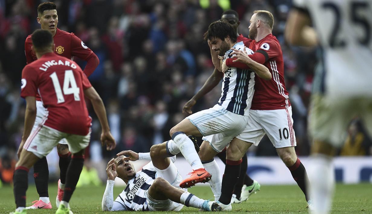 Striker Manchester United, Wayne Rooney, bersitegang dengan gelandang West Bromwich Albion, Claudio Yacob. Hasil Imbang ini bisa membuat Manchester United turun peringkat andai Arsenal menang atas Manchester City. (AFP PHOTO / Oli Scarff)