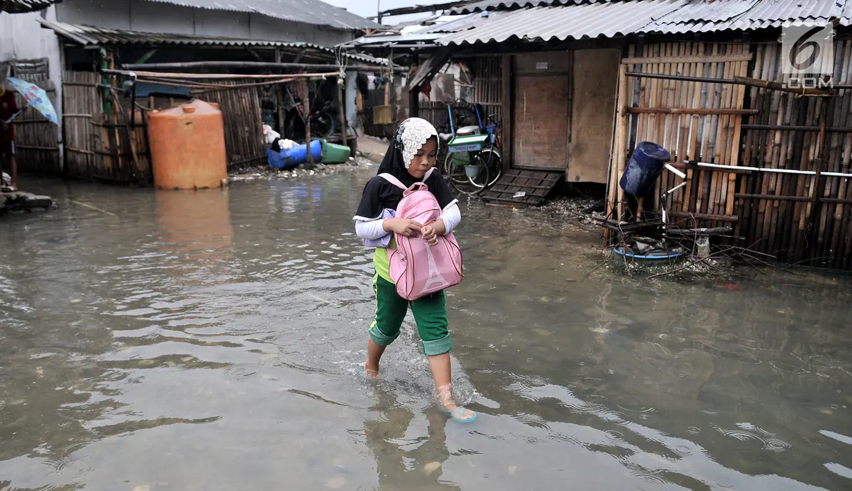 Seorang anak melintasi banjir rob yang menggenangi permukiman Muara Angke, Jakarta, Selasa (22/1). Banjir air laut pasang atau Rob yang kembali melanda kawasan itu sejak 6 hari lalu membuat aktivitas warga sekitar terganggu. (Merdeka.com/Iqbal S. Nugroho)