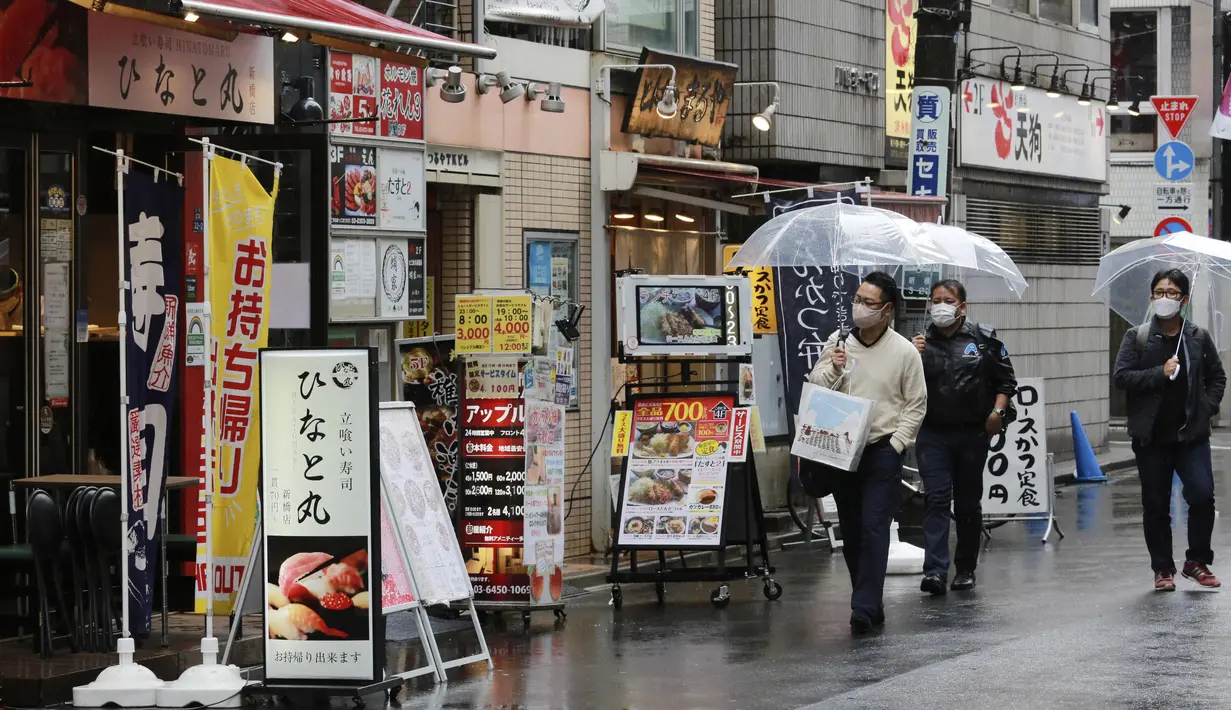 Warga memakai masker untuk melindungi dari penyebaran virus corona berjalan di jalan yang dipenuhi bar dan restoran di Tokyo (8/3/2021). Pemerintah Jepang memperpanjang keadaan darurat di wilayah Tokyo hingga 21 Maret karena sistem medis masih disaring oleh pasien COVID-19. (AP Photo/Koji Sasahara)