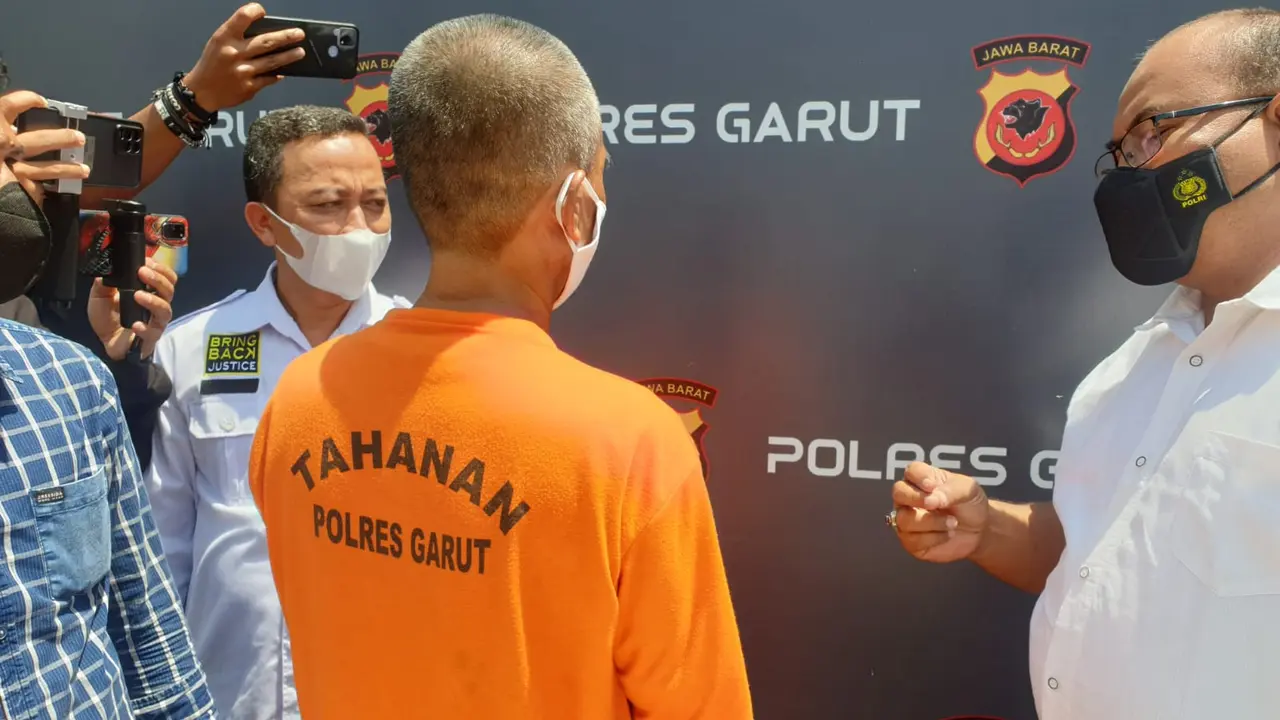 Kasatreskrim Polres Garut AKP Dede Sopandi, tengah berdiskusi dengan MA, tersangka kasus pembakaran SMPN 1 Cikelet, di sela-sela rilis kasus, di Mapolres Garut, Selasa (25/1/2022).
