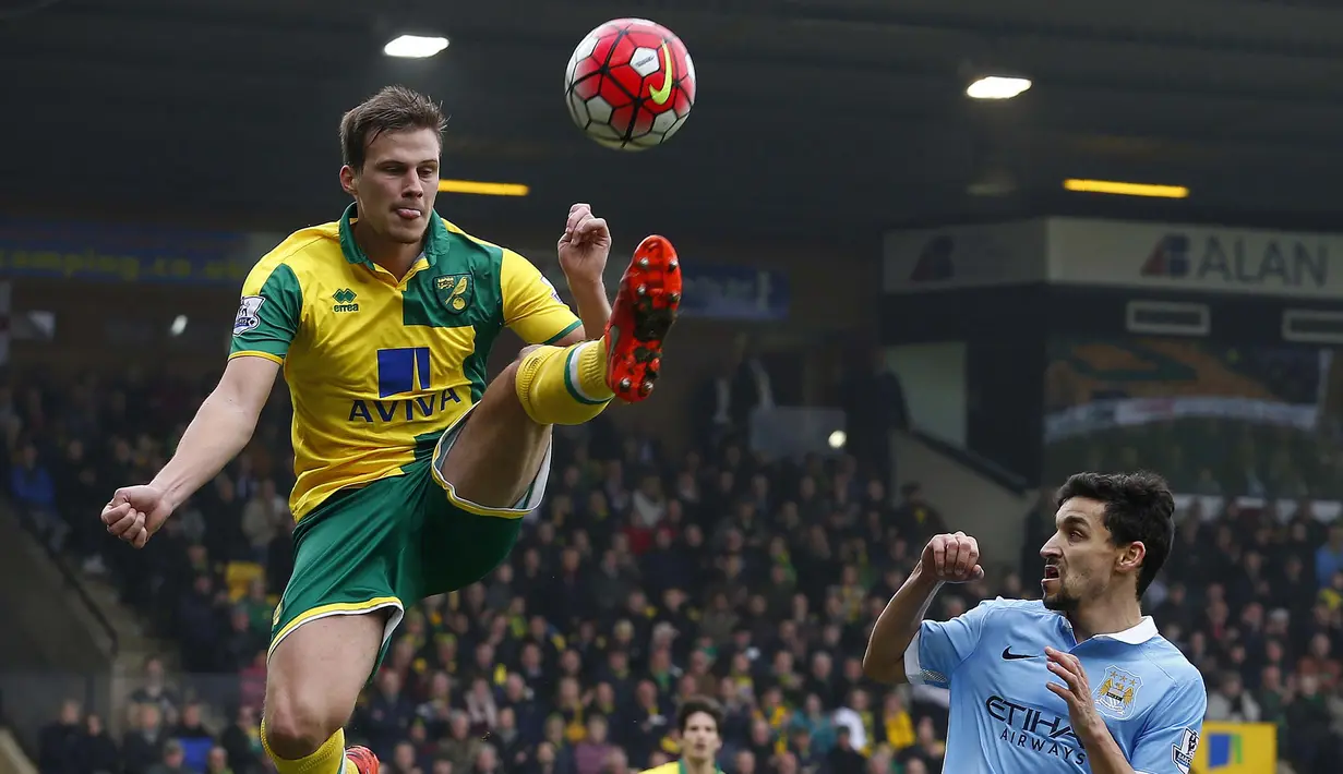 Pemain Norwich City, Ryan Bennett (kiri) berusaha menghalau bola dari kejaran pemain Manchester City,  Jesus Navas pada lanjutan liga Inggris pekan ke-30 di Stadion Carrow Road, Norwich, Sabtu (12/3/2016).  (AFP/Lindsey Parnaby)