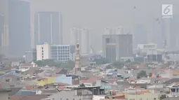 Pemandangan gedung-gedung pencakar langit dan permukiman warga saat tertutup polusi udara di Jakarta, Minggu (8/9/2019). Pada Minggu pagi kualitas udara DKI Jakarta berada pada level US Air Quality Index (AQI US) sebesar 130 atau berkategori tidak sehat bagi masyarakat sensitif. (merdeka.com/Iqbal S