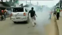 Polisi menembakkan gas air mata untuk membubarkan bentrokan. 