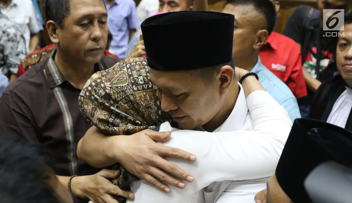 Bupati Lampung Tengah nonaktif, Mustafa memeluk istrinya usai menjalani sidang putusan di Pengadilan Tipikor, Jakarta, Senin (23/7). Sebelumnya, JPU KPK menuntut Mustafa dengan hukuman selama 4,5 tahun. (Liputan6.com/Helmi Fithriansyah)