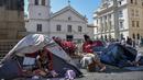 Sebuah keluarga tunawisma terlihat di tenda-tenda yang didirikan di Patio do Colegio, pusat kota Sao Paulo, Brasil, pada 19 Agustus 2021. Sao Paulo menghadapi krisis tunawisma, karena harga baru-baru ini menjadi beban yang terlalu berat bagi populasi yang semakin miskin. (NELSON ALMEIDA / AFP)