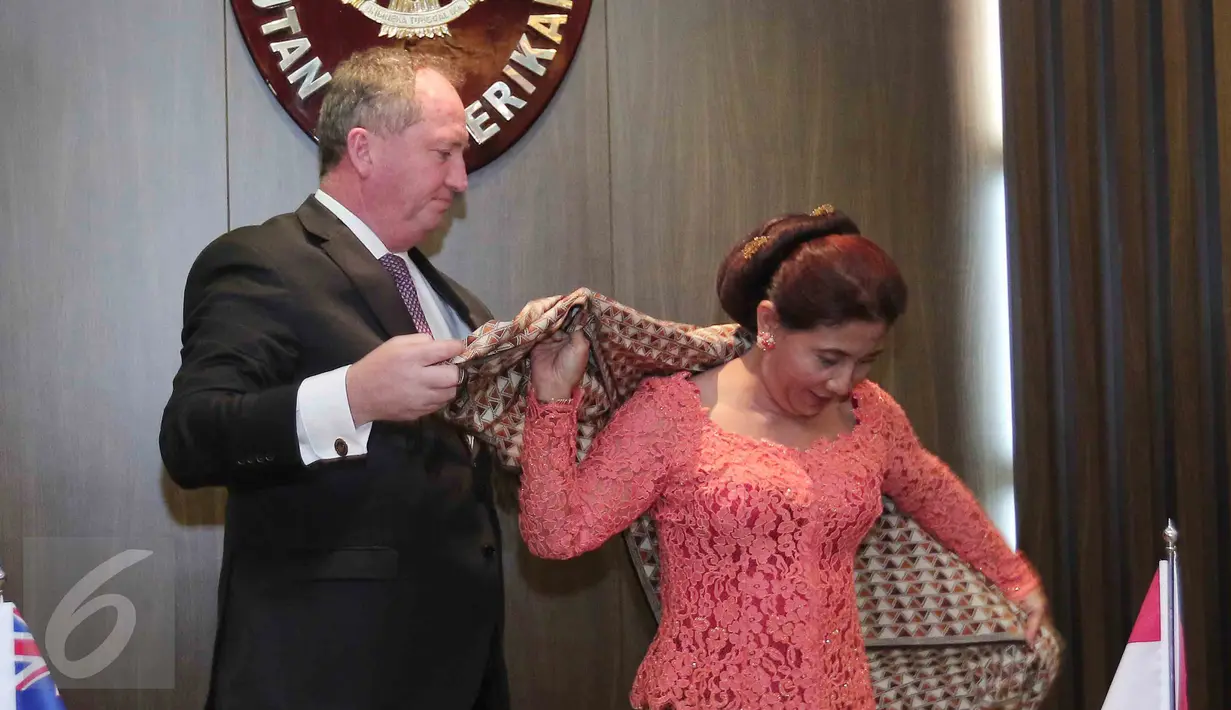 Menteri Pertanian dan Sumber Daya Air Australia, Hon Barnaby Joyce membantu Menteri Susi memakai selendang batik, Jakarta, Rabu (7/10/2015). Indonesia dan Australia sepakat memberantas praktik illegal fishing.(Liputan6.com/Angga Yuniar)
