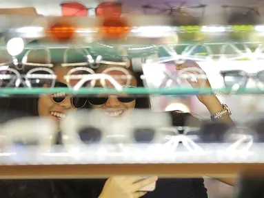 Dua wanita mencoba kaca mata di salah satu stand bazar dalam acara Fimela Fest 2018, Jakarta, Jumat (16/11). Fimela Fest 2018 diselenggarakan mulai tanggal 13-18 November 2018 di Gandaria City Mall, Jakarta. (Fimela.com/Bambang Ekoros Purnama)