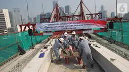 Pekerja melakukan pengecoran akhir jembatan lengkung bentang panjang atau long span pada proyek LRT Jabodebek di Kuningan, Jakarta, Senin (11/11/2019). Long span yang dibangun dengan metode balanced cantilever itu memiliki tipe box girder dengan radius lengkung 115 meter. (Liputan6.com/Angga Yuniar)