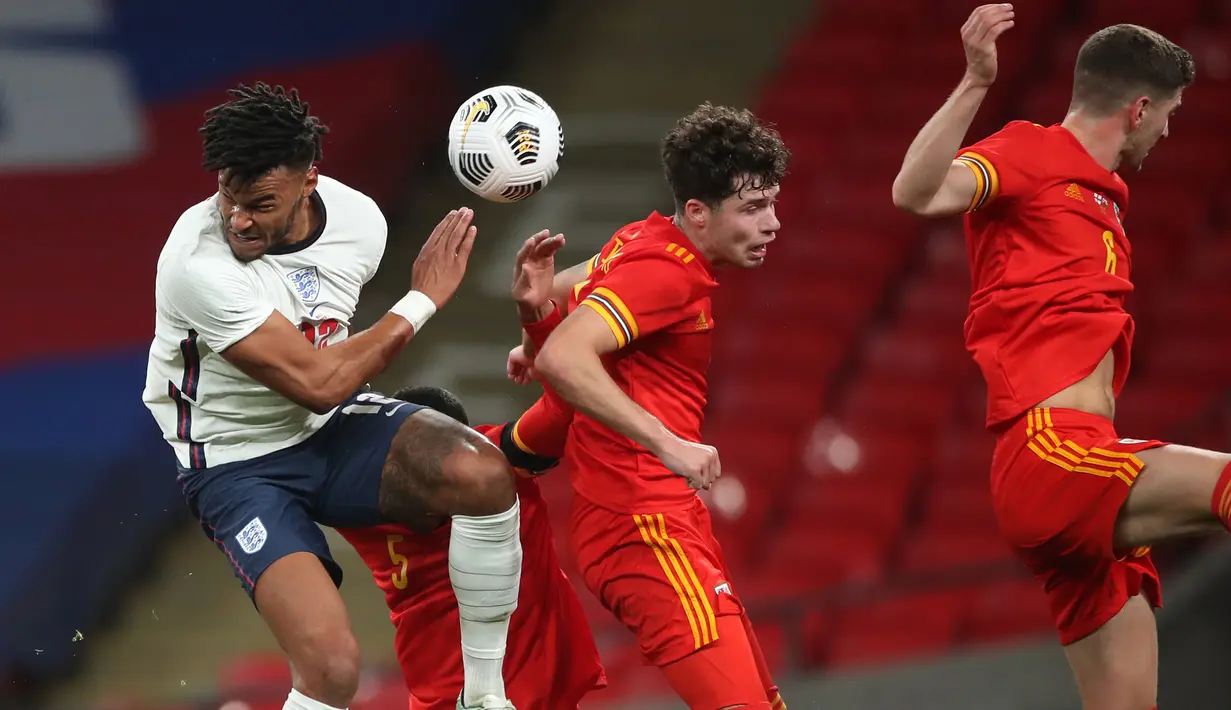 Bek Inggris, Tyrone Mings, berebut bola dengan bek Wales, Ben Cabango, pada laga persahabatan di Stadion Wembley, Jumat (9/10/2020) dini hari WIB. Inggris menang 3-0 atas Wales. (AFP/Nick Potts/pool)