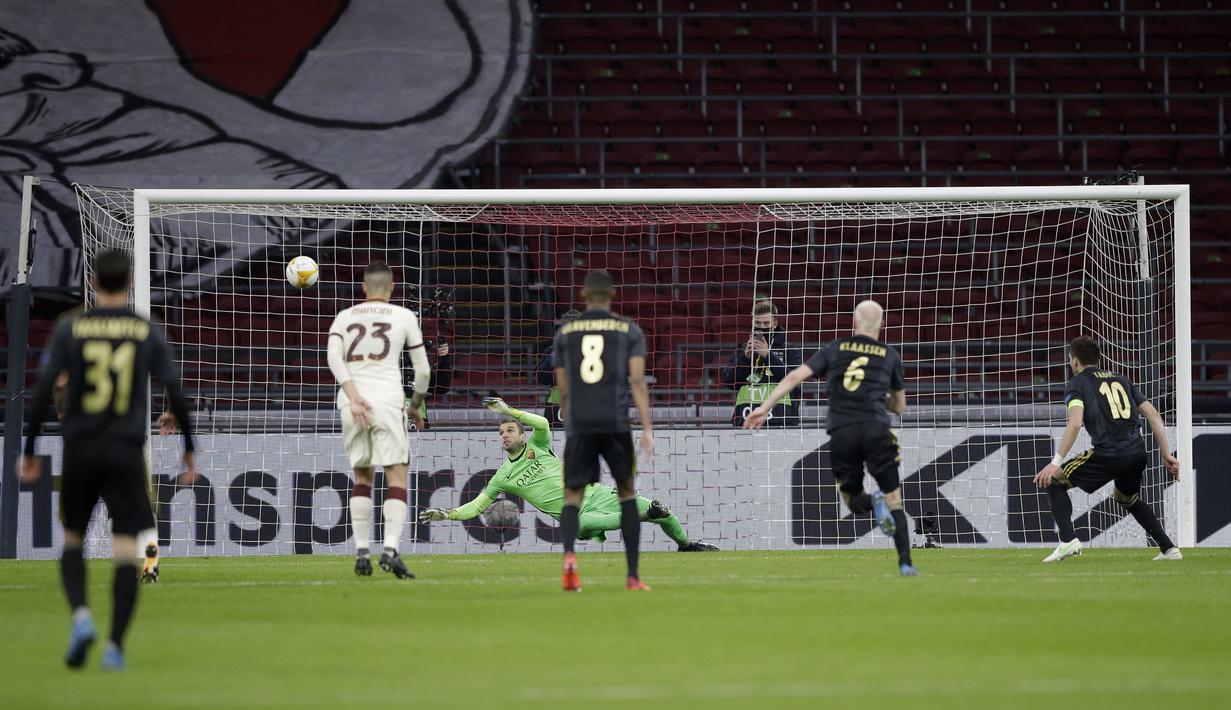 Kiper AS Roma, Pau Lopez (tengah) berhasil menghalau eksekusi penalti yang dilakukan striker Ajax Amsterdam, Dusan Tadic (kanan) dalam laga leg pertama perempatfinal Liga Europa 2020/2021 di Johan Cruijff Arena, Amsterdam, Kamis (8/4/2021). AS Roma menang 2-1 atas Ajax. (AP/Peter Dejong)