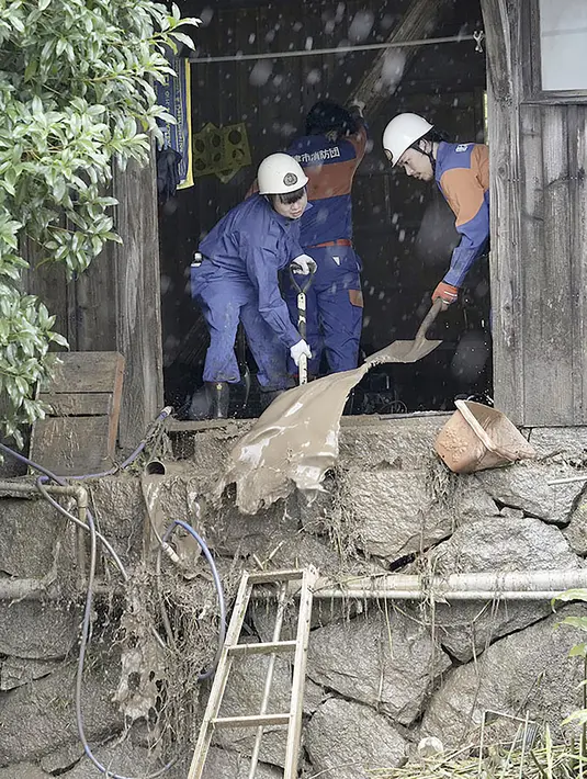 Petugas pemadam kebakaran menyedot lumpur dari sebuah rumah yang rusak akibat tanah longsor di Karatsu, Prefektur Saga, Jepang selatan Senin, 10 Juli 2023. (Kyodo News via AP)