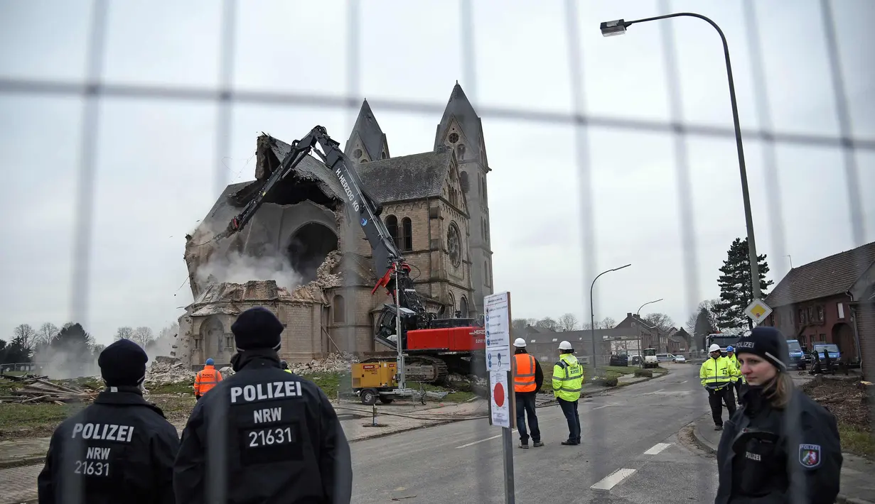 Petugas dibantu alat berat membongkar Gereja St. Lambertus di Desa Immerath, Jerman (8/1). Pembongkaran dilakukan untuk perluasan pertambangan batubara, penghasil energi listrik. (AFP Photo/Henning Kaiser)