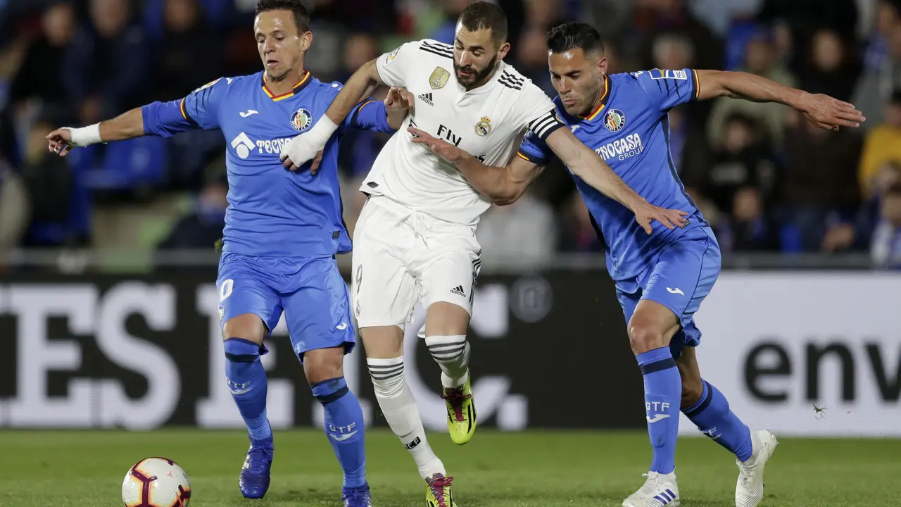 Striker Real Madrid, Karim Benzema (tengah) dikawal ketat dua pemain Getafe