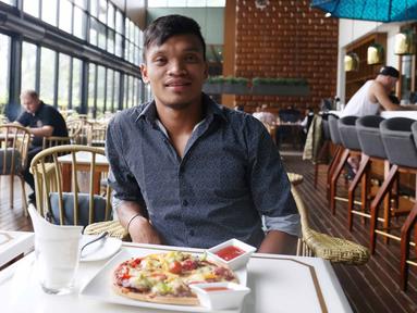 Pemain Sriwijaya FC, Ferdinand Sinaga menikmati Piza usai menjalani sidang Komisi Disiplin di Hotel Century, Senayan. Jakarta, Jumat (4/12/2015). (Bola.com/Nicklas Hanoatubun)