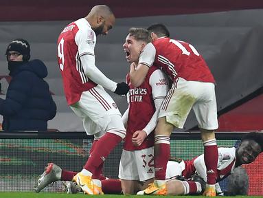 Gelandang Arsenal, Emile Smith Rowe (tengah) melakukan selebrasi bersama rekan setim usai mencetak gol pertama timnya ke gawang Newcastle United dalam laga babak ke-3 Piala FA 2020/21 di Emirates Stadium, Sabtu (9/1/2021). Arsenal menang 2-0 atas Newcastle melalui extra time. (AFP/Glyn Kirk/Pool)