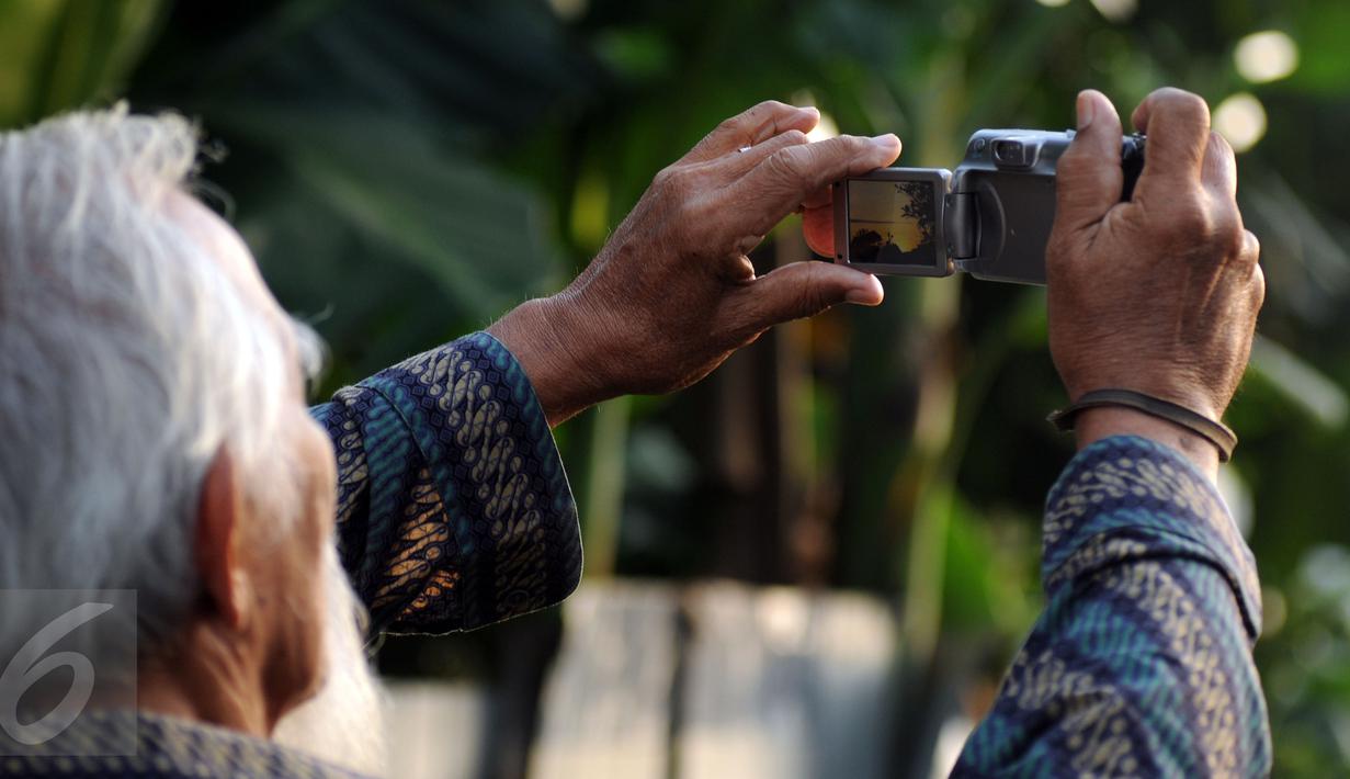 Warga menggunakan kamera digital untuk menyaksikan proses gerhana matahari di sekitar Taman Ismail Marzuki, Jakarta, Rabu (9/3/2016). Di Jakarta, fenomena gerhana matahari 90% bisa diamati selama 2,11 menit. (Liputan6.com/Helmi Fithriansyah)   