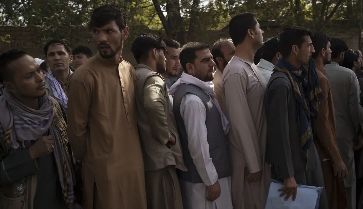 Warga Afghanistan berbaris di luar kantor pembuatan paspor pemerintah yang baru-baru ini dibuka kembali di Kabul, Rabu (6/10/2021). Mereka mengantre setelah Taliban mengumumkan akan mengeluarkan paspor yang disetujui oleh pemerintahan sebelumnya. (AP Photo/Felipe Dana)