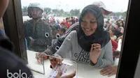 Ekspresi senang seorang suporter saat menerima tiket yang dibelinya pada loket pembelian tiket di Stadion Pakansari, Bogor, Sabtu (11/3/2017). (Bola.com/Nicklas Hanoatubun)