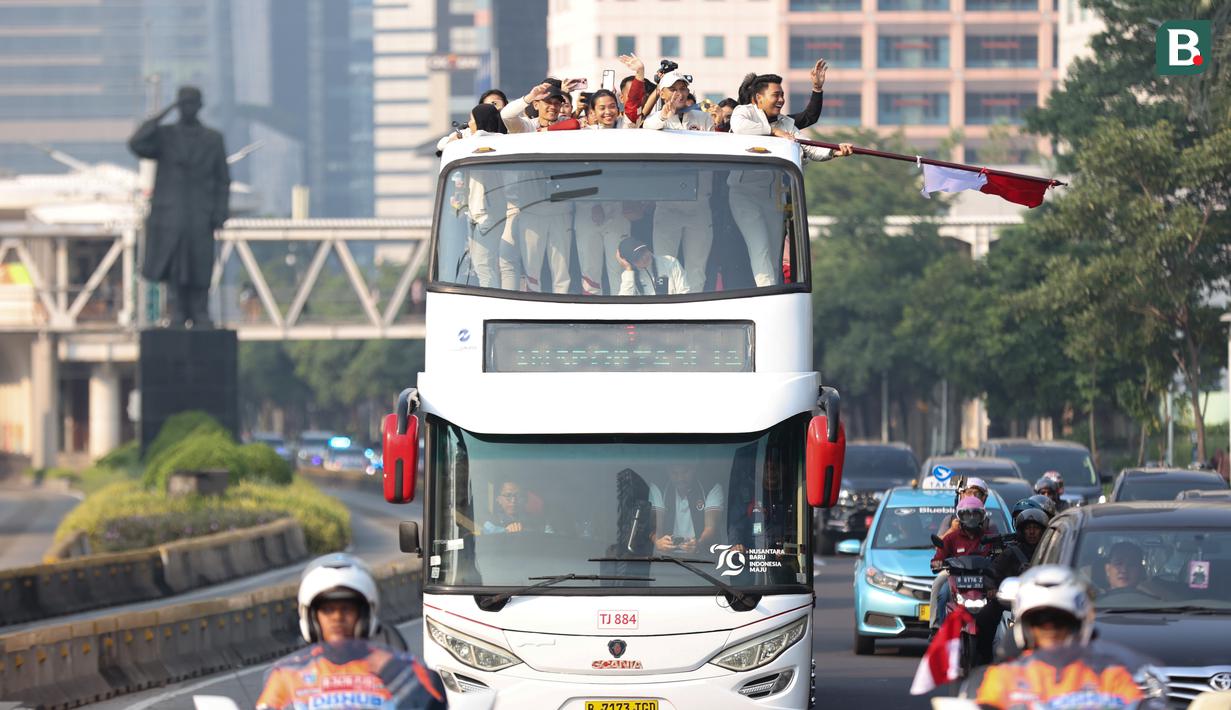 Sejumlah atlet dan ofisial Kontingen Indonesia pada Olimpiade Paris 2024, termasuk peraih medali emas, Veddriq Leonardo dan Rizki Juniansyah serta peraih medali perunggu, Gregoria Mariska Tunjung mengikuti pawai dengan menaiki bus tingkat terbuka Transjakarta menuju Istana Negara, Jakarta Pusat, Kamis (15/8/2024). (Bola.com/Abdul Aziz)