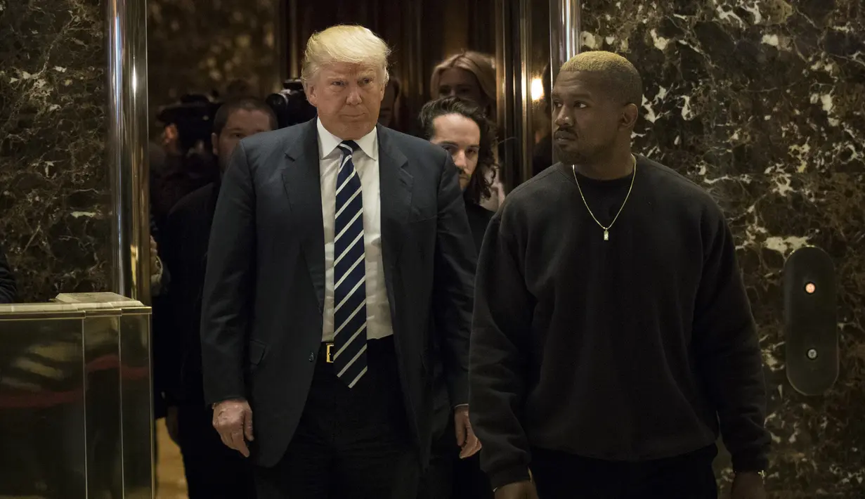 Presiden AS terpilih, Donald Trump dan Kanye West berjalan keluar dari lift usai melakukan pertemuan di Trump Tower, New York, Selasa (13/12). Menurut West, ia ingin membicarakan masalah-masalah multikultural dengan Trump. (Drew Angerer/Getty Images/AFP)