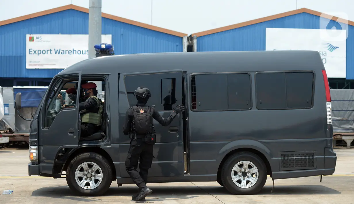 Mobil yang membawa terduga teroris terparkir saat anggota Densus 88 Antiteror berjaga di Bandara Soekarno-Hatta, Tangerang, Banten, Kamis (18/3/2021). Polri memindahkan 22 terduga teroris jaringan kelompok Jamaah Islamiyah (JI) dari Jawa Timur ke Jakarta. (merdeka.com/Imam Buhori)
