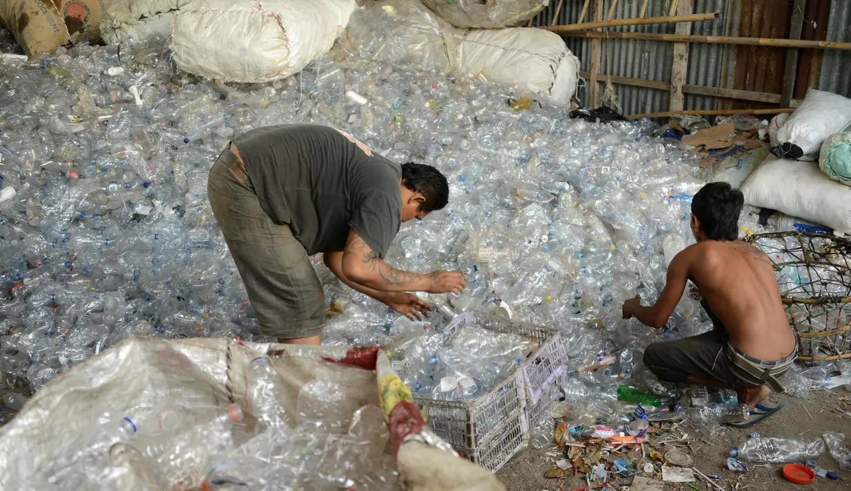 Pengumpul sampah memilih botol plastik di sebuah gudang sampah di Nusa Dua, di pulau resor Indonesia Bali (2/5). (AFP Photo/Sonny Tumbelaka)