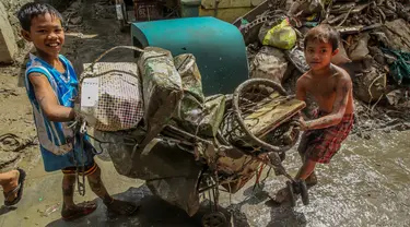 Anak-anak mengumpulkan barang-barang mereka dari endapan lumpur dan sampah beberapa hari setelah bencana banjir yang dipicu oleh Topan Vamco di Marikina City, Filipina, pada 19 November 2020. Dunia merayakan Hari Anak Sedunia tahun ini pada Jumat (20/11). (Xinhua/Rouelle Umali)