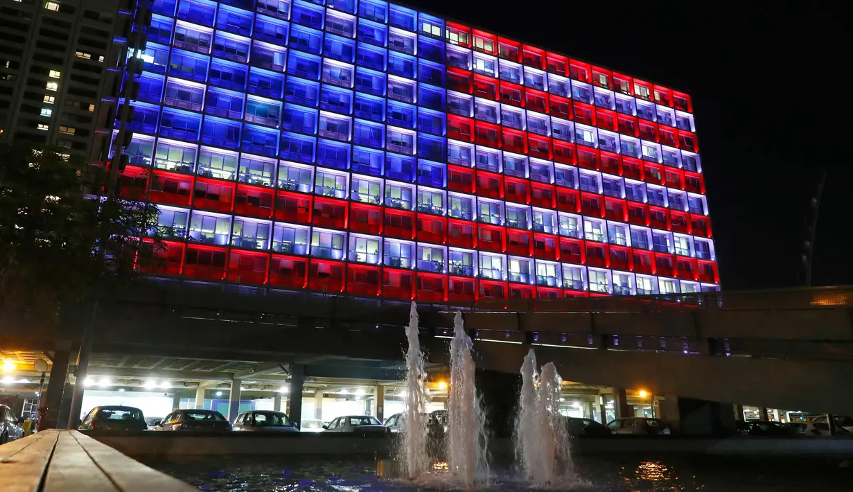 Pemendangan balai kota Tel Aviv yang dihiasi warna bendera AS untuk menghormati korban penembakan brutal di Las Vegas di Rabin Square, Tel Aviv (2/10). Pelaku penembakan diketahui bernama Stephen Paddock 64 tahun. (AFP Photo/Jack Guez)