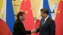 Presiden Filipina Rodrigo Duterte berjabat tangan dengan Presiden Xi Jinping seusai pertemuan dua negara di Beijing (20/10). Pertemuan tersebut membuat kebijakan luar negri Filipina yang lebih condong ke Tiongkok daripada ke AS. (Reuters/ Ng Han Guan)