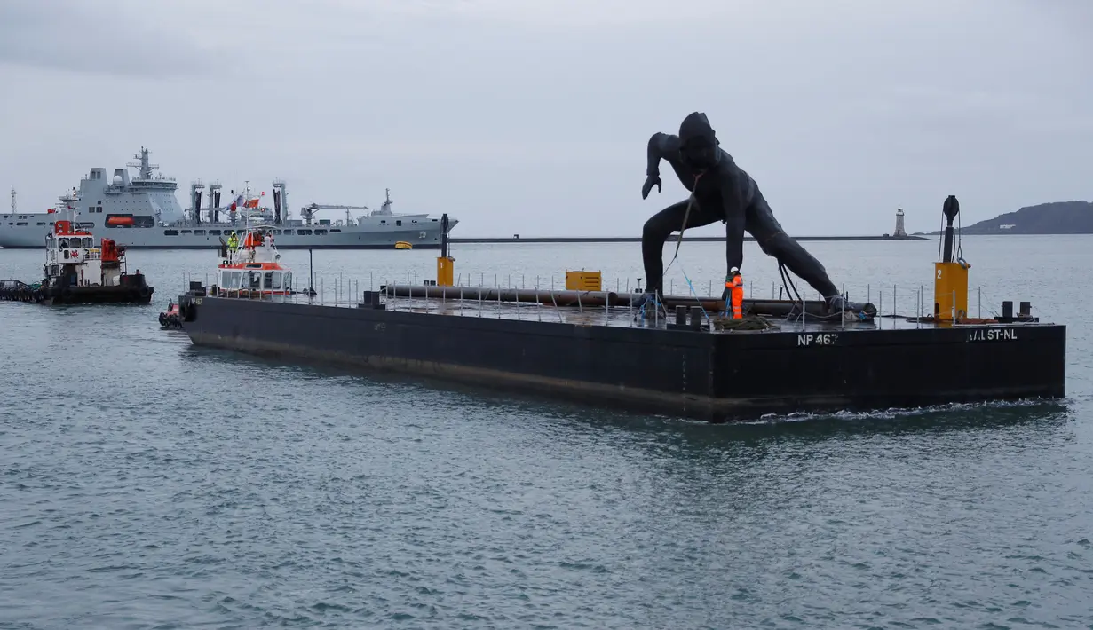 Patung perunggu terbesar di Inggris,  berjudul 'Messenger' tiba dengan tongkang di pesisir pantai Plymouth, Senin (18/3). Patung perunggu tersebut diciptakan oleh seorang pematung berusia 44 tahun bernama Joseph Hillier. (REUTERS/Peter Nicholls)