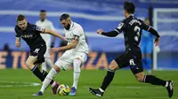 Karim Benzema dari Real Madrid, tengah, mengontrol bola antara pemain Real Sociedad, Igor Zubeldia, kiri, dan Martin Zubimendi selama pertandingan sepak bola La Liga Spanyol antara Real Madrid dan Real Sociedad, di stadion Santiago Bernabeu di Madrid, Minggu, 29 Januari 2023 (AP Photo/Manu Fernandez)