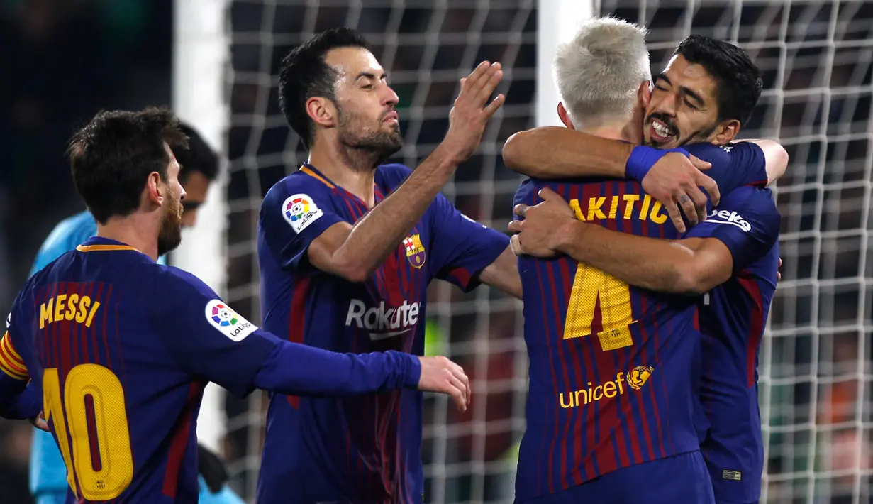 Pemain Barcelona, Luis Suarez dan rekan setimnya, Ivan Rakitic merayakan gol ke gawang Real Betis pada pertandingan lanjutan La Liga di Stadion Benito Villamarin, Minggu (21/1). Barcelona menyegel kemenangan dengan skor 5-0. (AP/Miguel Morenatti)